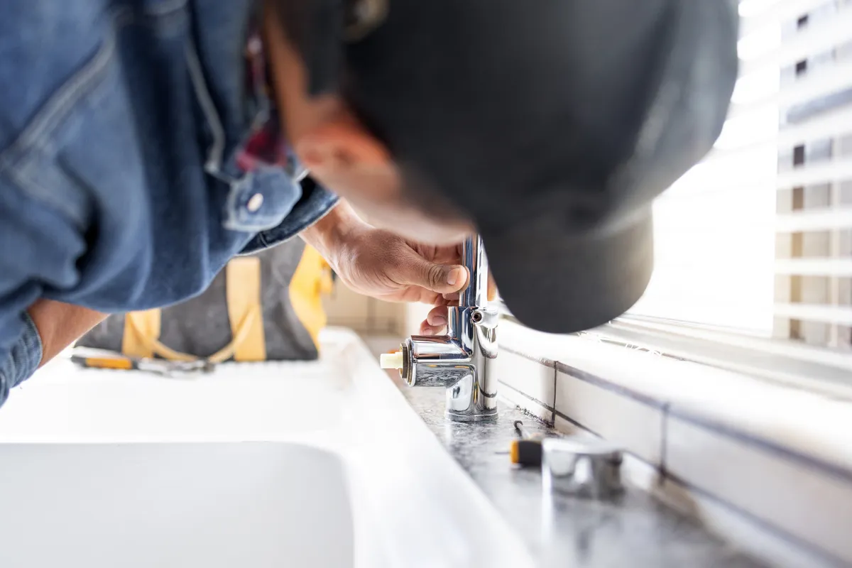 Plumber fixing faucet